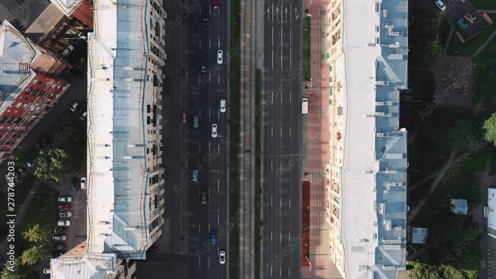 Aerial view from above of cars moving along the road between the houses Aerial view from above of cars moving along the road between the houses