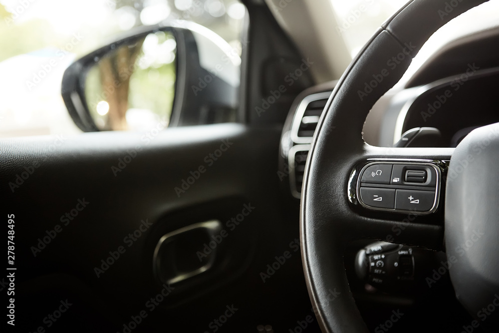 selective focus of steering wheel near gear shift handle in luxury car