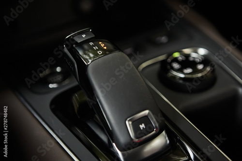 Automotive detail in a luxury car. Modern Luxury car inside. Interior of prestige modern car. Automatic gear stick shift