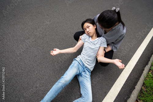 Sick child girl with epileptic seizures on street,daughter suffering from seizures,illness with epilepsy during seizure attack,asian woman or mother care of girl patient,brain,nervous system concept photo