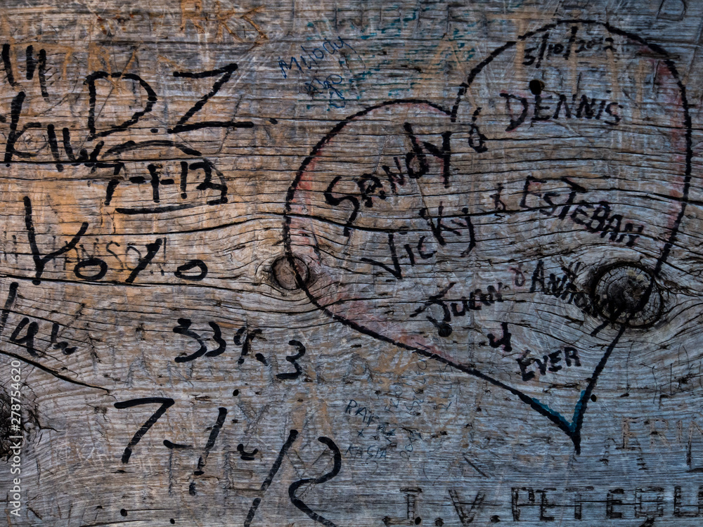 wood bank marked with names, dates and a heart wood bank marked with names, dates and a heart