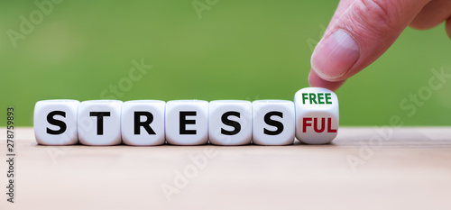 Hand turns a cube and changes the expression "stressful" to "stress free".