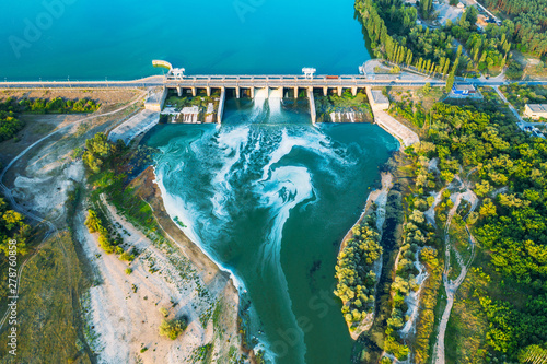 Fényképezés Aerial panoramic view of concrete Dam at reservoir with flowing water, hydroelec