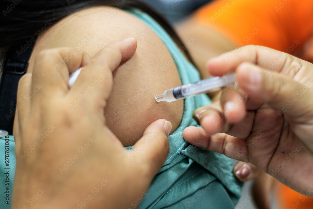 Nurse  making a vaccination to the shoulder of patient