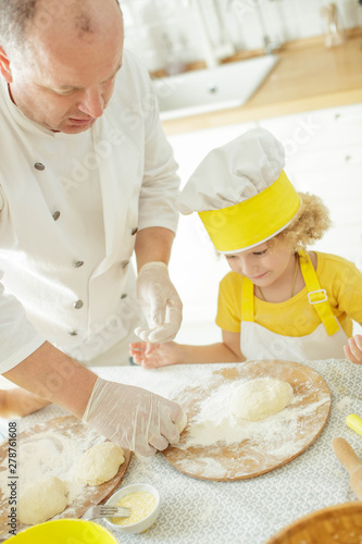 Children cook in the kitchen. Happy child learns to cook in the kitchen delicious chef chef. 