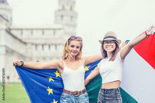 Young teen girls traveler with italian and european union flags  before the historic tower in town Pisa - Italy © weyo