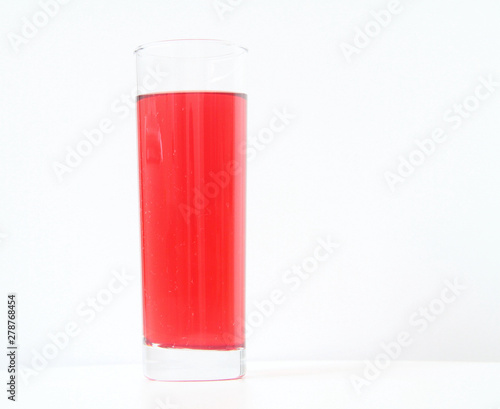 Glass of red liquid on white background, São Paulo, Brazil photo