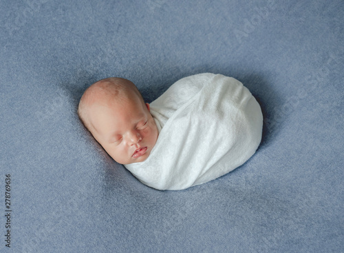 Newborn child sleeping in blanket photo