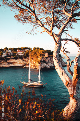 Luxury sail yacht is the best way to travel and spend time at the sea. Sunset view of a bay with warm color tones. Cala Portals Vells, Mallorca. Balearic Islands photo