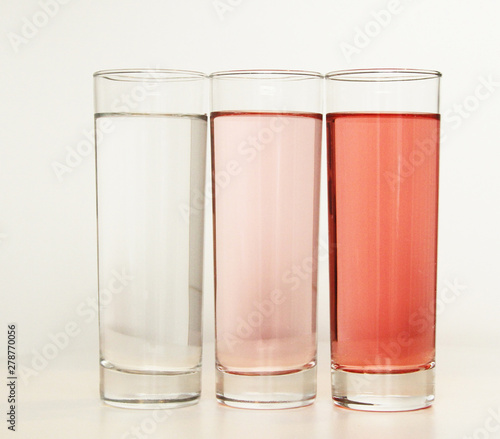 Three glasses of red and transparent liquid on white background, São Paulo, Brazil