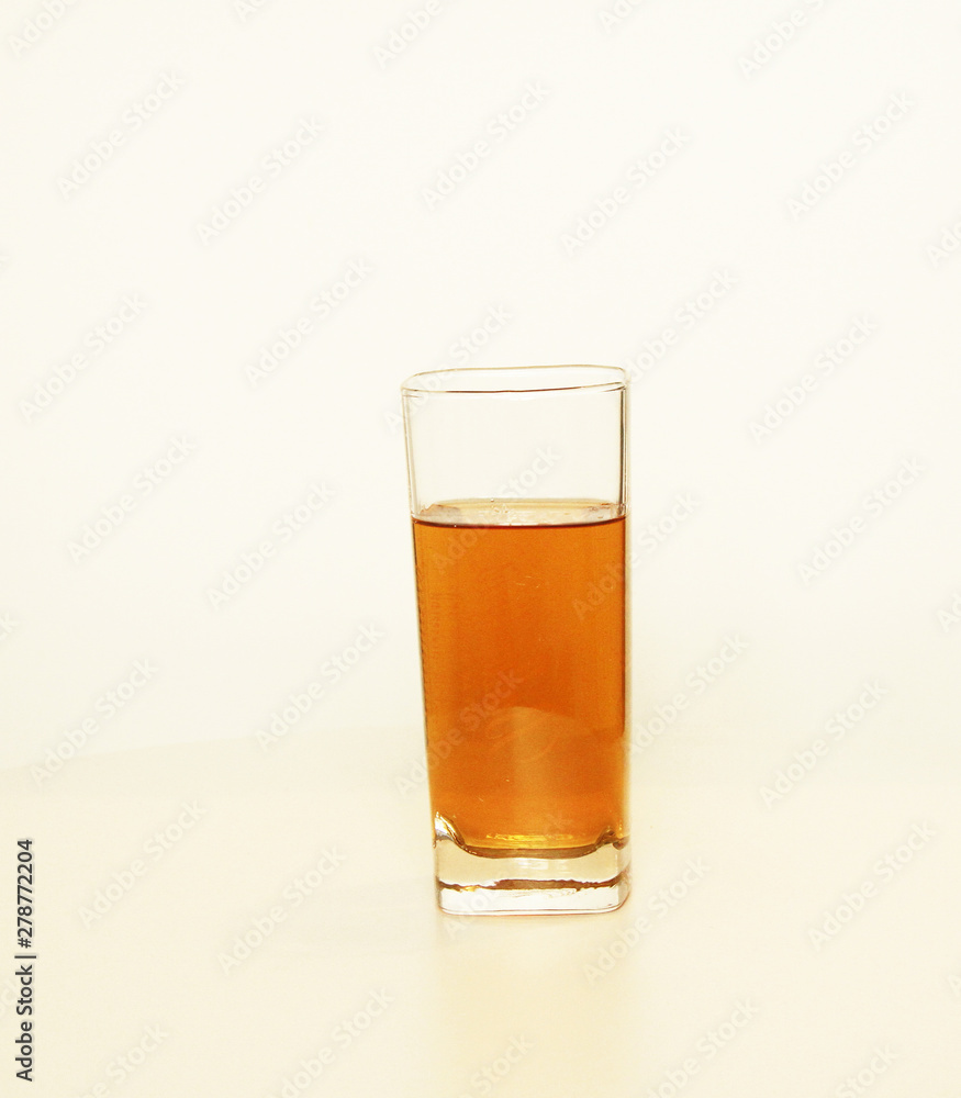 One glass of yellow and transparent liquid on white background, São Paulo, Brazil One glass of yellow and transparent liquid on white background, São Paulo, Brazil