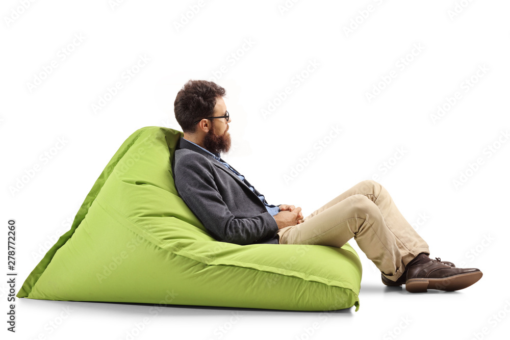 Bearded man sitting on a modern green bean bag chair Bearded man sitting on a modern green bean bag chair