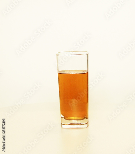 One glass of yellow and transparent liquid on white background, São Paulo, Brazil