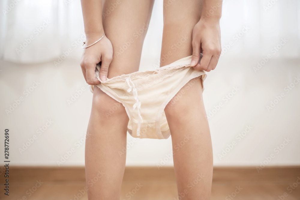 Young woman pull off her panties in the bedroom Stock Photo