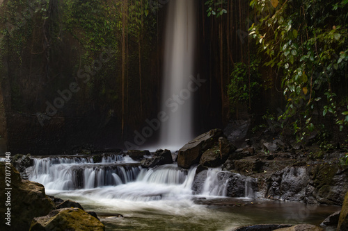Waterfall landscape. Beautiful hidden Sumampan waterfall in tropical rainforest in Bali near Ubud. Slow shutter speed, motion photography. © Olga
