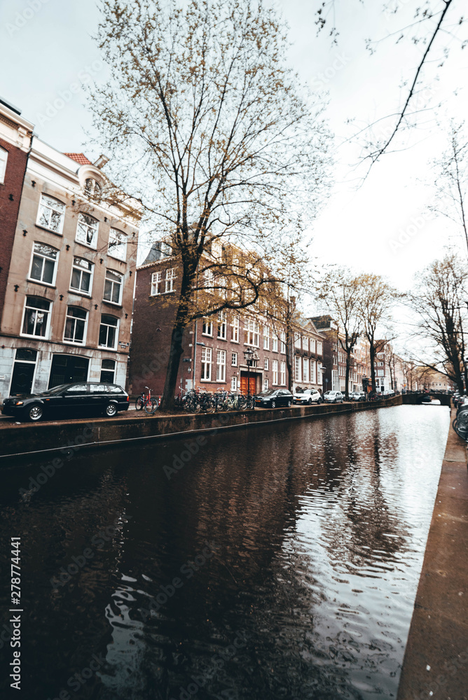 Fototapeta premium Amsterdam canal with buildings on the back