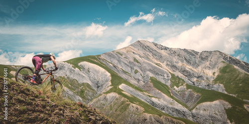 Fényképezés Mountain biker descending in the Alps