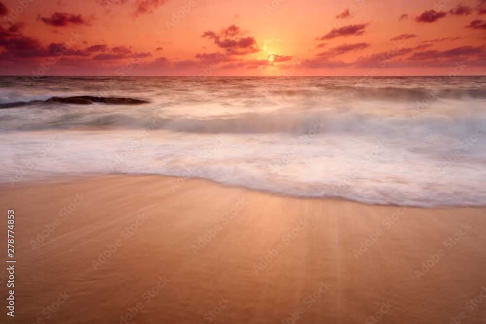 Beautiful natural seascape wave move on the sand during sunset