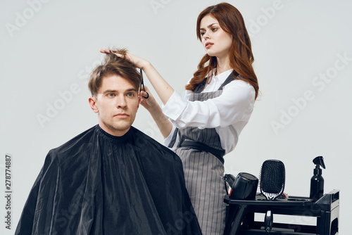 Woman hairdresser doing hairstyle