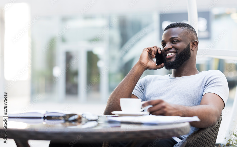 Successful african guy drinking coffee and speakig on cellphone Successful african guy drinking coffee and speakig on cellphone