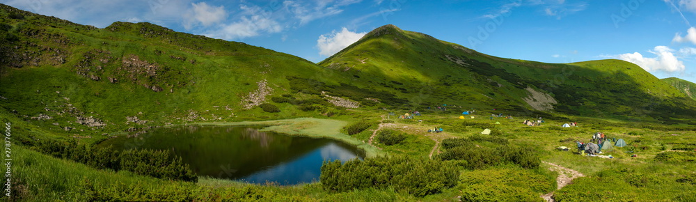 Lake Nesamovite in the Carpathians in the summer sunny day. Alpine lake in the mountains in the summer season. Amazing mountain landscape in mountain valley. Montenegrin Range in the Carpathians.