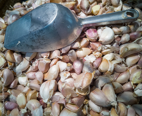 A lot of garlic piles With a metal ladle placed