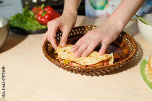 Girl cook cooks delicious tortilla pork and fresh vegetables