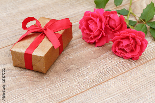 Gift box with rose flowers on the background.