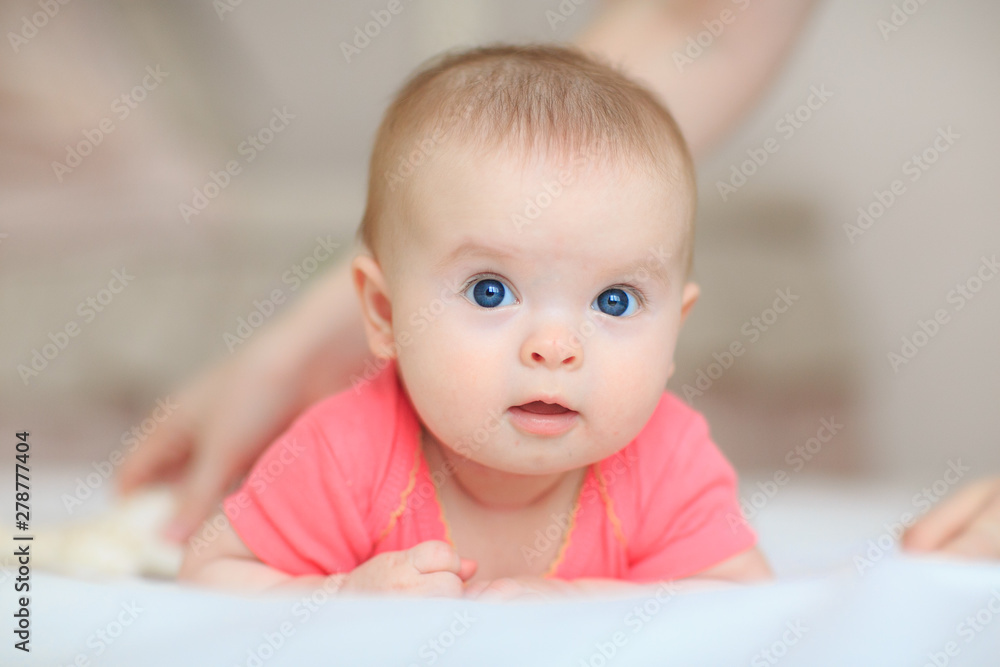 A cute little baby is looking into the camera. little baby with blue eyes