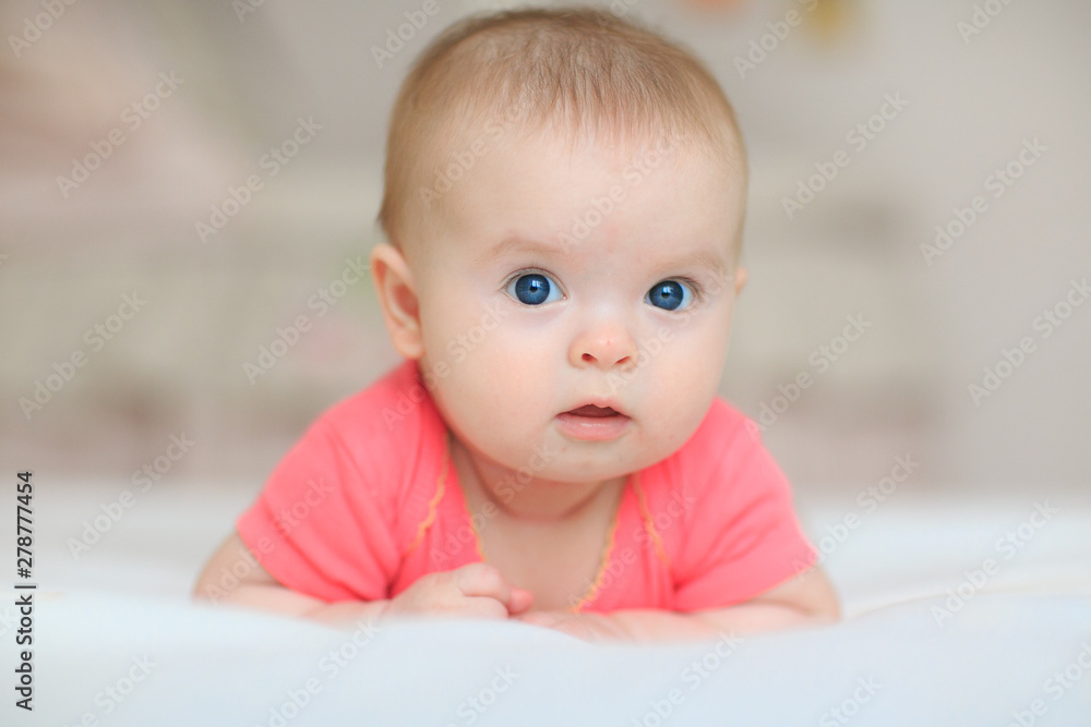 A cute little baby is looking into the camera. little baby with blue eyes A cute little baby is looking into the camera. little baby with blue eyes