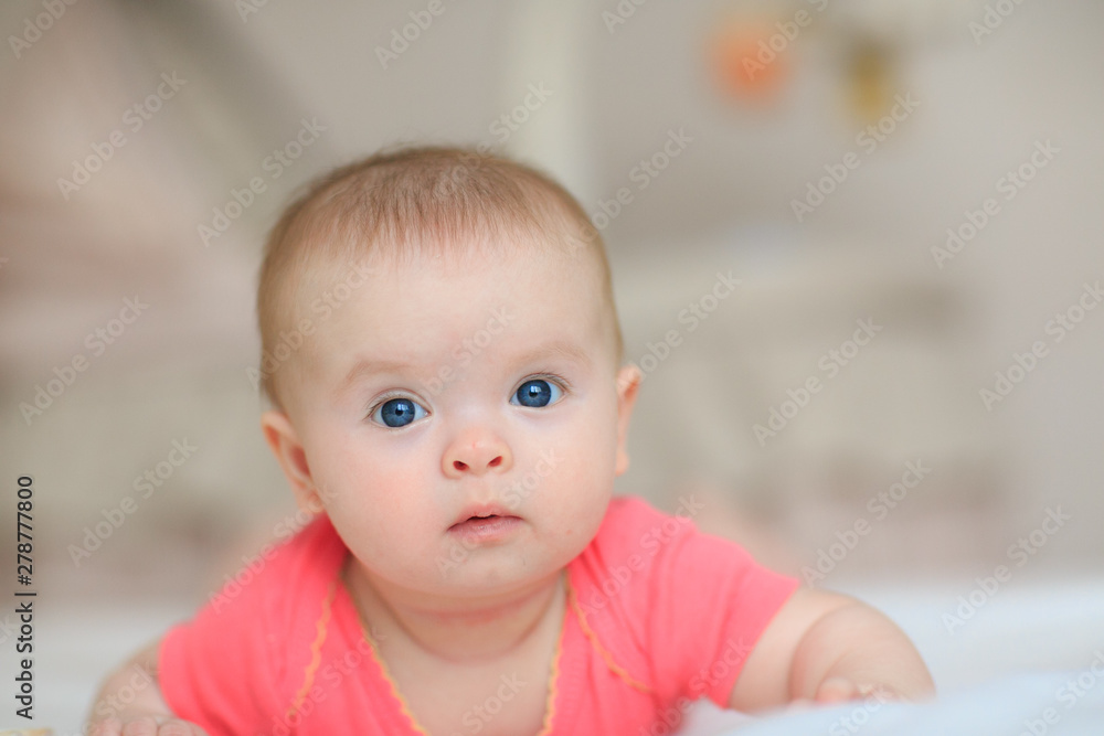 Portrait of pretty baby girl with blue eyes. Cute little baby girl looking into the camera