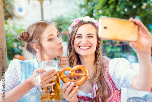 Best friends in Bavarian Tracht making a Selfie with the phone