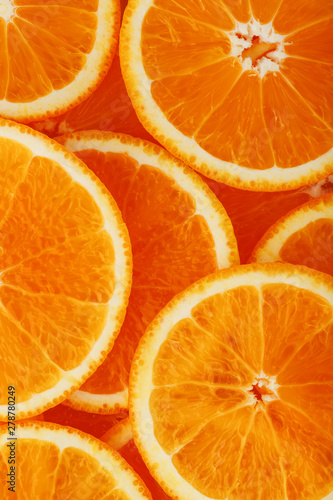 Slices of ripe orange backlit as a textural background. Full screen, close-up, macro