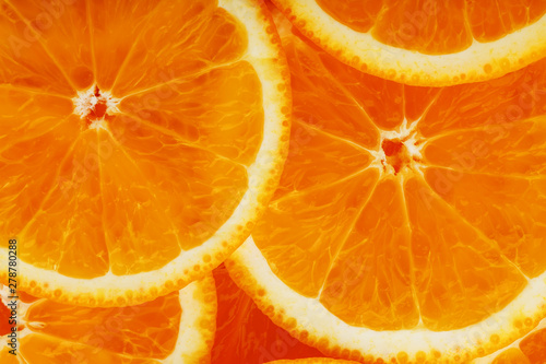 Slices of ripe orange backlit as a textural background. Full screen, close-up, macro