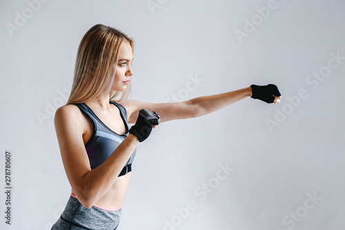 Athletic girl blonde in gloves takes a punch