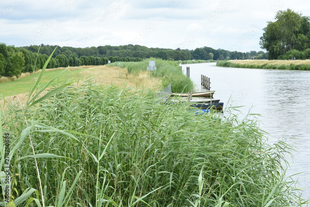 Fototapeta premium rowing boats at a quay in river Oude IJssel in the Achterhoek