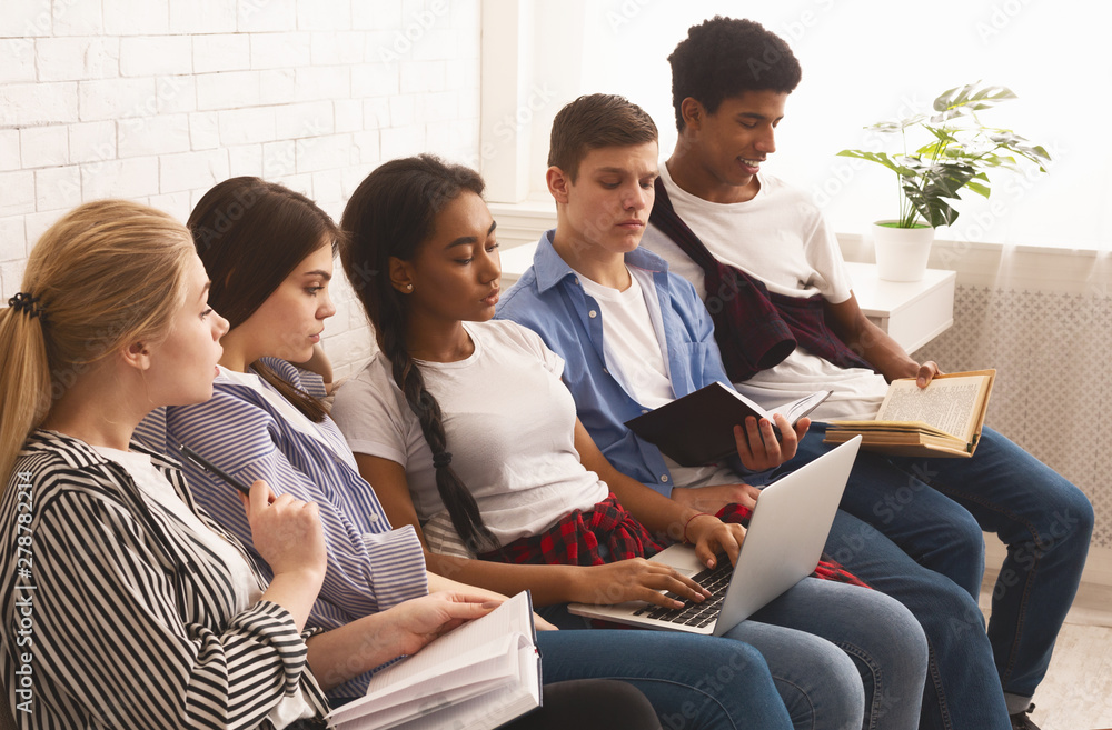 Concentrated teen students preparing for exams, sitting on sofa Concentrated teen students preparing for exams, sitting on sofa