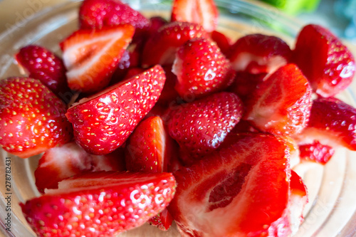 Fresh strawberries sliced in a glass bowl.