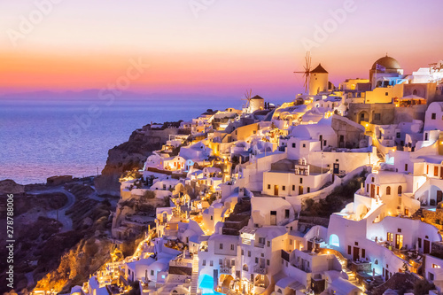 Beautiful view of fabulous picturesque village of Oia with traditional white houses and windmills in Santorini island at night, Greece