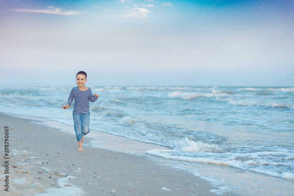 Child running on the beach. Summer vacation. happy kid playing on beach at the sunset time Child running on the beach. Summer vacation. happy kid playing on beach at the sunset time