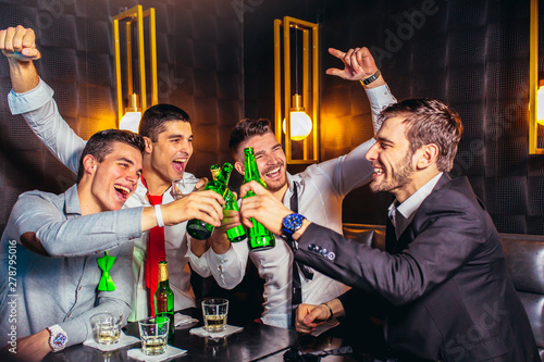 Group of young men toasting at a nightclub photo