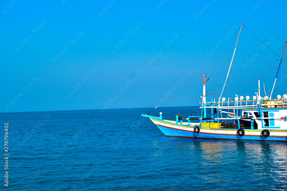 Traditional sailing wooden boat on the water parking at the harbour in summer holiday in Lampung, Indonesia Traditional sailing wooden boat on the water parking at the harbour in summer holiday in Lampung, Indonesia