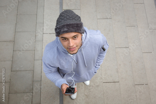 Listening to music young latin man runner sports training from above top view