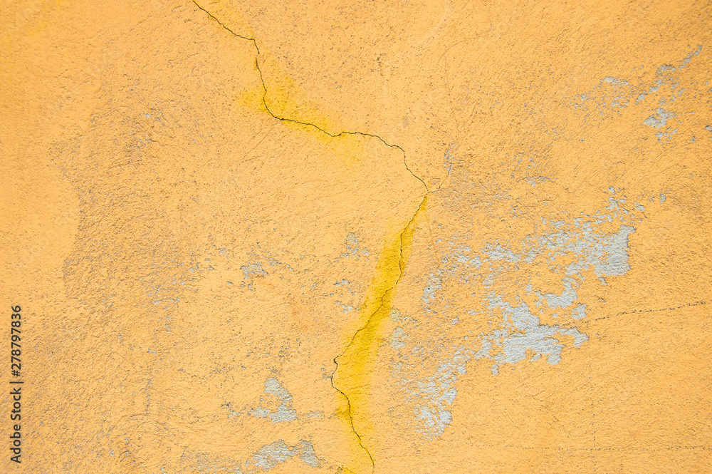 Fototapeta premium Yellow bright wall texture background with a crack