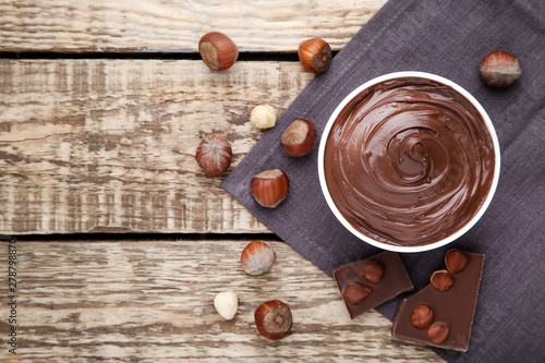 Melted chocolate with hazelnuts on brown wooden table