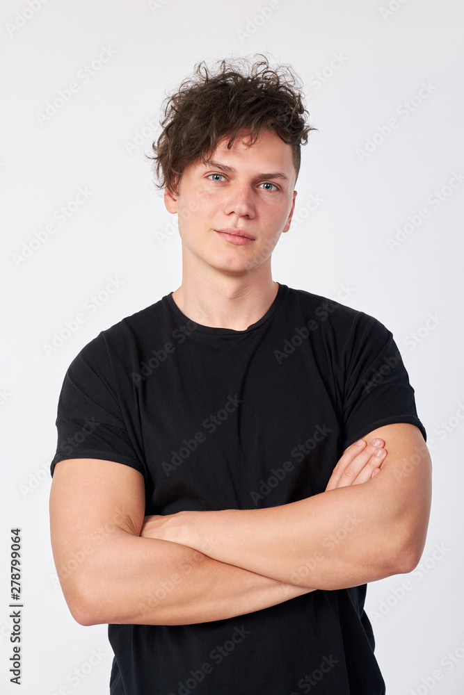 Portrait of handsome young stylish man wearing a black cotton short-sleeved T-shirt posing in studio. Studio shot on a white background. Portrait of handsome young stylish man wearing a black cotton short-sleeved T-shirt posing in studio. Studio shot on a white background.