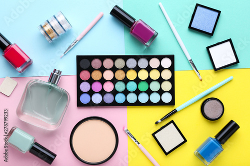 Makeup cosmetics with perfume bottle on colorful background
