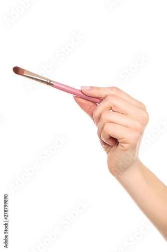 Makeup brush in female hand on white background