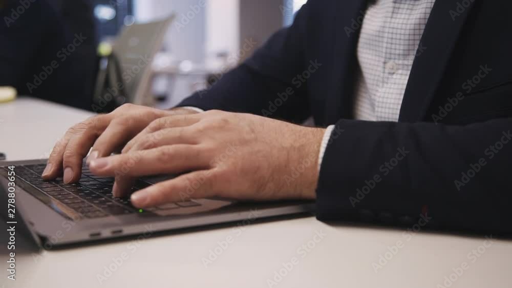 American businessman using vr glasses sitting at table with laptop in office. Front view of young man with black headset on face is watching video and playing game, get amazing virtual experience American businessman using vr glasses sitting at table with laptop in office. Front view of young man with black headset on face is watching video and playing game, get amazing virtual experience