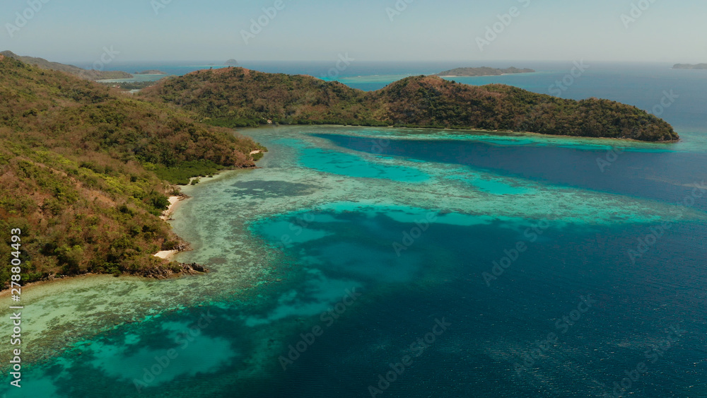 aerial view tropical island Bulalacao with blue lagoon, coral reef and sandy beach. Palawan, Philippines. Islands of the Malayan archipelago with turquoise lagoons. aerial view tropical island Bulalacao with blue lagoon, coral reef and sandy beach. Palawan, Philippines. Islands of the Malayan archipelago with turquoise lagoons.